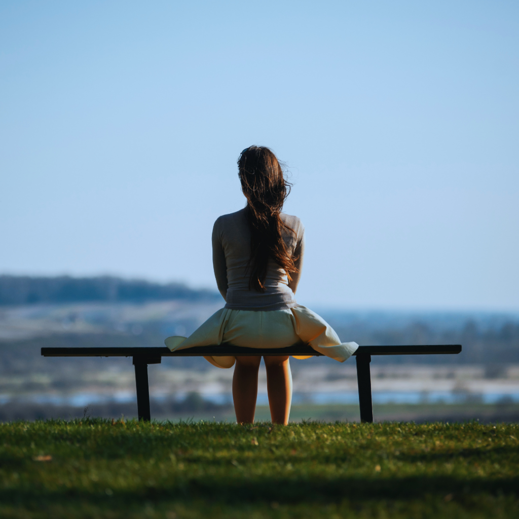 Woman sitting alone on a bench enjoying a quiet moment in nature